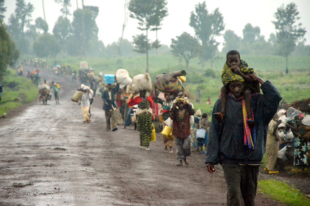 Residents of the town of Kibumba walk o