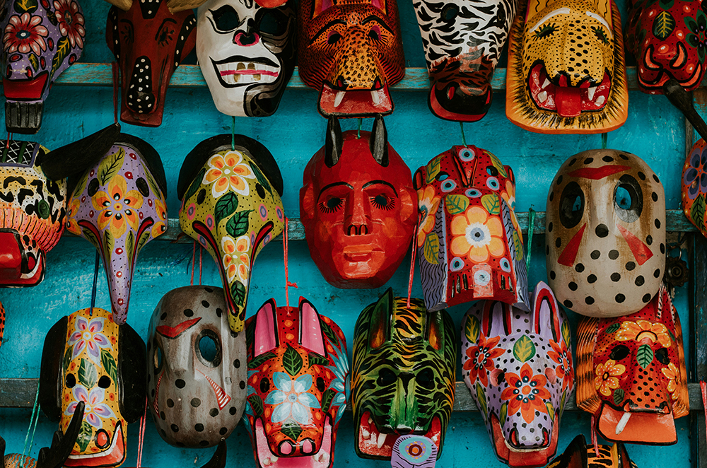 A colourful wall display of traditional masks symbolising the hidden dangers of falling in love with the wrong person.