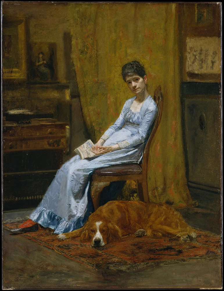 A woman in a pale blue dress sits alone with a book in her hands while a large brown dog rests on a rug at her feet.